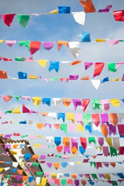 İpe asılı farklı renkte bayraklar. Saint John 'un dekorasyonu. Haziran kutlaması. Mavi gökyüzüne karşı