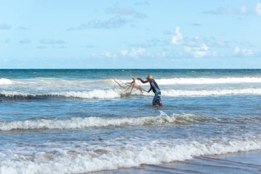 Salvador, Bahia, Brezilya - 26 Nisan 2019: Balıkçı, Bahia 'nın Salvador kentindeki Jaguaribe sahiline balık ağı atarken görüldü.