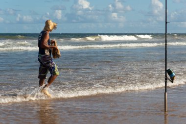 Salvador, Bahia, Brezilya - 26 Nisan 2019: Balıkçılar Salvador, Bahia kentindeki Jaguaribe plajı boyunca yürürken görüldü.