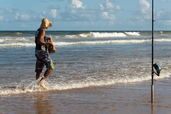 Salvador, Bahia, Brezilya - 26 Nisan 2019: Balıkçılar Salvador, Bahia kentindeki Jaguaribe plajı boyunca yürürken görüldü.