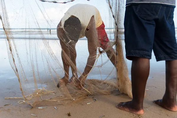 Salvador, Bahia, Brezilya - 26 Nisan 2019: Balıkçılar, Bahia 'nın Salvador kentindeki Jaguaribe sahilinde bir balık ağına dokunurken görüldü..