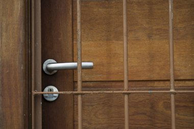 Kapalı ahşap kapı ve önünde demir ızgara. Güvenlik