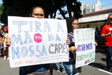 Salvador, Bahia, Brezilya - 30 Mayıs 2019: İnsanlar, Bahia 'nın Salvador kentinde Başkan Jair Bolsonaro' nun eğitim fonlarındaki kesintileri protesto eden posterlerle görülüyor.