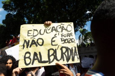 Salvador, Bahia, Brezilya - 30 Mayıs 2019: Bahia 'nın Salvador kentinde Başkan Jair Bolsonaro' nun eğitim için para kesintilerini protesto eden posterli insanlar görülüyor.