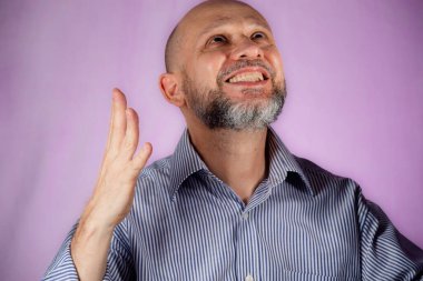 Pembe arka planda işaret veren bir adam.