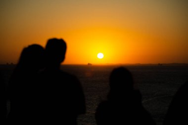 Güzel günbatımının tadını çıkaran insanların silueti. Tabiat ana