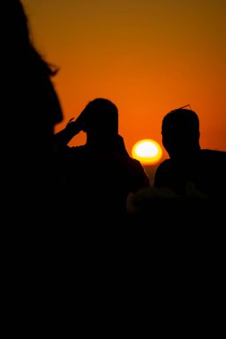 Güzel günbatımının tadını çıkaran insanların silueti. Tabiat ana