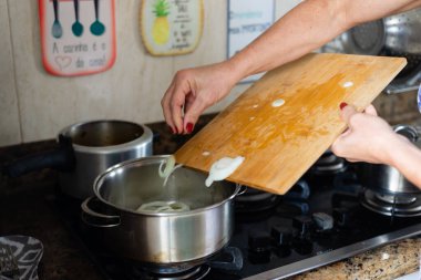 Soğanlar tavaya konuyor. Yiyecek çeşnisi.