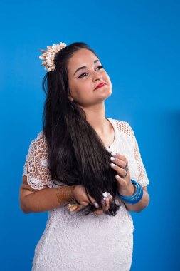 Kafasında deniz kabuğu tacı olan beyaz elbiseli güzel genç bir kadın yan tarafa bakıyor. Özelleştirilmiş: Iemanja.