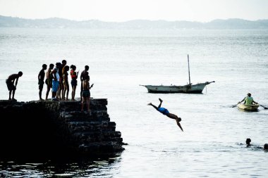 Salvador, Bahia, Brezilya - 05 Ocak 2022: İnsanlar Bahia 'nın Salvador kentindeki Porto da Barra iskelesinden atlarken görüldü.