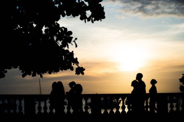 Salvador, Bahia, Brezilya - 05 Ocak 2022: Salvador, Bahia kentindeki Porto da Barra plajı boyunca yürüyen insanların silueti.