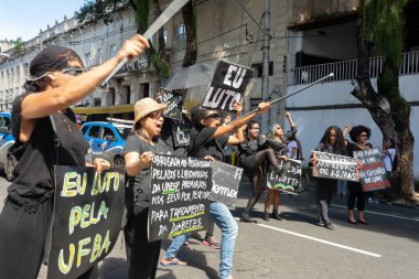 Salvador, Bahia, Brezilya - 30 Mayıs 2019: İnsanlar, Bahia 'nın Salvador kentinde Başkan Jair Bolsonaro' nun eğitim fonlarındaki kesintileri protesto eden posterlerle görülüyor.