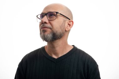 Beyaz, kel, reçeteli gözlüklü, düşünceli ve ciddi, yana bakıyor. Beyaz arkaplanda izole.