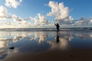 Salvador, Bahia, Brezilya - 27 Nisan 2019: Balıkçı, şafak vakti Bahia 'nın Salvador kentindeki Jaguaribe sahilinde balık tutarken görüldü..