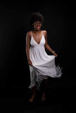 Siyah saçlı, gülümseyen gözlüklü güzel bir kadının stüdyo portresi. Siyah arkaplanda izole.