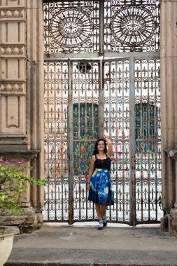 Güzel, siyah saçlı bir kadın, antika demir korkuluklara yaslanmış renkli hatıra kurdeleleriyle dolu. Seyahat eden kişi.