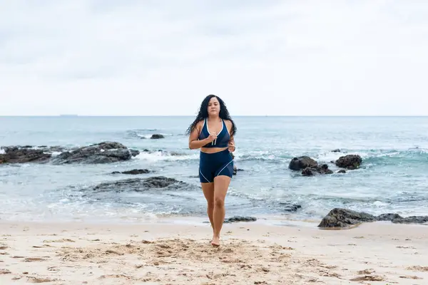 Fitness woman, athlete, doing exercises on the beach running towards the camera. Healthy lifestyle.