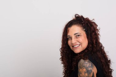 Güzel kıvırcık saçlı, siyah elbiseli, gülümseyen ve mutlu bir kadın. Beyaz arkaplanda izole.