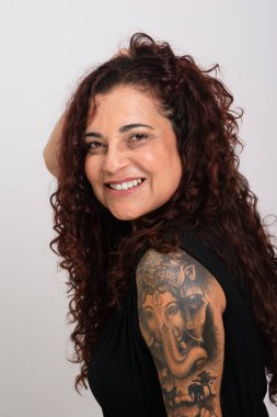 Güzel kıvırcık saçlı, siyah elbiseli, gülümseyen ve mutlu bir kadın. Beyaz arkaplanda izole.