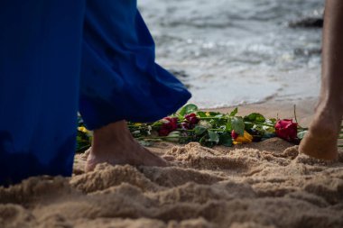 Plaj suyunda ıslanan kimliği belirsiz insanların bacaklarının alt kısmı. Iemanja 'ya haraç.