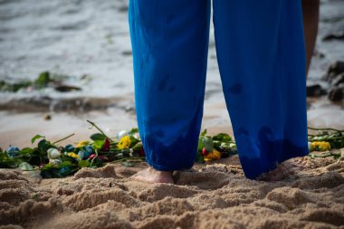 Plaj suyunda ıslanan kimliği belirsiz insanların bacaklarının alt kısmı. Iemanja 'ya haraç.