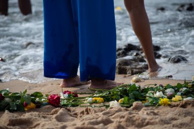 Plajdaki kimliği belirsiz insanların bacaklarının alt kısmı. Iemanja 'ya haraç.