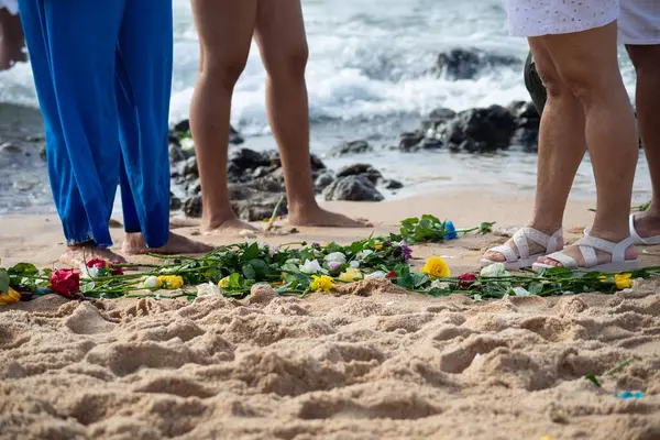 Plajdaki kimliği belirsiz insanların bacaklarının alt kısmı. Iemanja 'ya haraç.