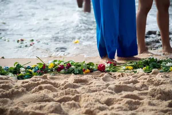 Plajdaki kimliği belirsiz insanların bacaklarının alt kısmı. Iemanja 'ya haraç.