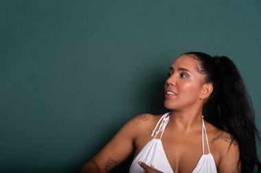 Sağ tarafa bakan güzel esmer kadının portresi. Kendine güvenen biri. Yeşil arkaplanda izole.