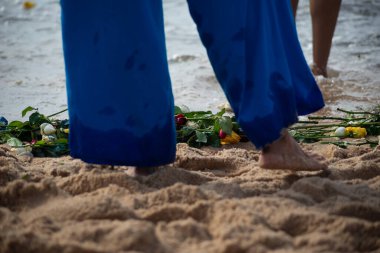 Plajdaki kimliği belirsiz insanların bacaklarının alt kısmı. Iemanja 'ya haraç.