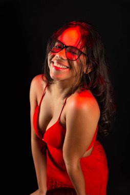 Salvador, Bahia, Brezilya - 09 Aralık 2023: Reçeteli gözlük takan ve fotoğraf için poz veren güzel bir genç kadın. Siyah arkaplanda izole.