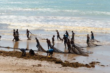 Salvador, Bahia, Brezilya - 25 Aralık 2018: Bahia 'nın Salvador kentindeki Boca do Rio plajında büyük balık ağlarını açan balıkçılar.