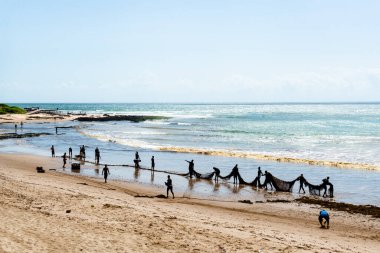 Salvador, Bahia, Brezilya - 25 Aralık 2018: Bahia 'nın Salvador kentindeki Boca do Rio plajında büyük balık ağlarını açan balıkçılar.