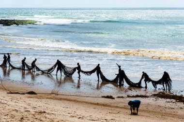 Salvador, Bahia, Brezilya - 25 Aralık 2018: Balıkçılar, Bahia 'nın Salvador kentindeki Boca do Rio plajında büyük bir balık ağı taşırken görüldü..
