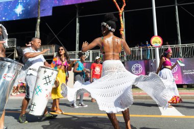 Salvador, Bahia, Brezilya - 3 Şubat 2024: Bahia kentinin Fuzue kentinde düzenlenen karnaval öncesi geçit töreninde kültür gruplarından insanlar dans ederken görülüyor.