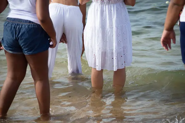 stock image Salvador, Bahia, Brazil - February 02, 2024: People enter the water at Rio Vermelho beach to pay homage to Iemanja in the city of Salvador, Bahia.