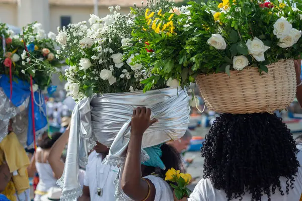 stock image Salvador, Bahia, Brazil - February 02, 2024: Candomble members are seen carrying a basket of flowers to offer to iemanja during a party on Rio Vermelho beach. Salvador, Bahia.