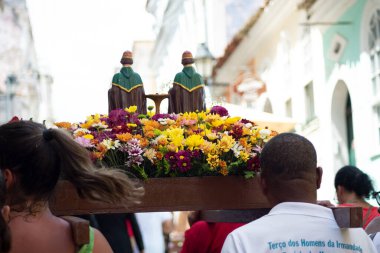 Salvador, Bahia, Brezilya - 4 Aralık 2023: Katolik inananlar, Salvador, Bahia şehrinde Santa Barbara onuruna düzenlenen geçit töreninde bir aziz figürü taşıyan bir yürüyüşçü olarak görüldü..