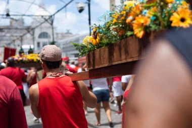 Salvador, Bahia, Brezilya - 4 Aralık 2023: Katolik inananlar, Salvador, Bahia şehrinde Santa Barbara onuruna düzenlenen geçit töreninde bir aziz figürü taşıyan bir yürüyüşçü olarak görüldü..
