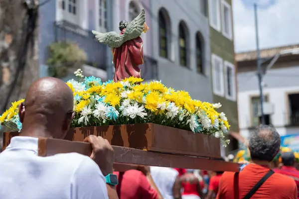 Salvador, Bahia, Brezilya - 4 Aralık 2023: Katolik inananlar, Salvador, Bahia şehrinde Santa Barbara onuruna düzenlenen geçit töreninde bir aziz figürü taşıyan bir yürüyüşçü olarak görüldü..