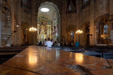 Salvador, Bahia, Brezilya - 5 Ocak 2024: Bahia kentinin ticari bölgesinde Conceicao da Praia kilisesinde inançlı kişiler namaz kılarken görülüyor.