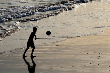 Salvador, Bahia, Brezilya - 14 Şubat 2019: Genç bir adam Salvador, Bahia 'da öğleden sonra eğlenirken ve plaj futbolu oynarken görüldü.