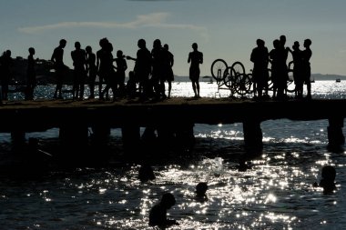 Salvador, Bahia, Brezilya - 09 Mart 2019: Silüet içinde düzinelerce genç Crush Köprüsü 'nün tepesinde eğlenirken görülüyor. Bahia, Salvador şehri..
