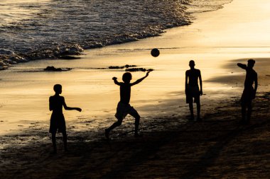 Salvador, Bahia, Brezilya - 14 Şubat 2019: Silüet içindeki gençler, Salvador, Bahia 'daki Ondina plajında plaj futbolu oynarken görülüyor.