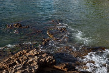 Karanlık deniz taşları. Güçlü güneşli bir gün. Korunmuş doğa.