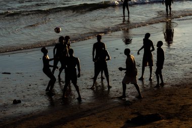 Salvador, Bahia, Brezilya - 14 Şubat 2019: Silüet içindeki gençler, Salvador, Bahia 'da günbatımında Ondina plajında plaj futbolu oynarken görülüyor.