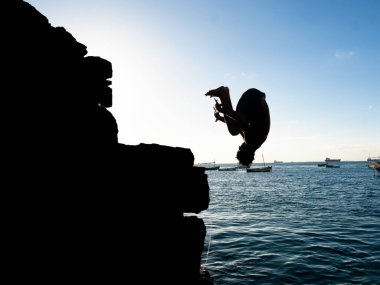 Salvador, Bahia, Brezilya - 31 Mayıs 2019: Salvador, Bahia kentindeki Porto da Barra rıhtımından denize atlayan bir turist görüldü..