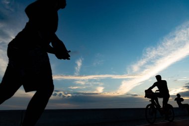 Salvador, Bahia, Brezilya - 19 Aralık 2021: İnsanlar Salvador, Bahia kentindeki Rio Vermelho plajında gün batımında gezinirken görüldü.