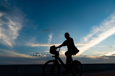 Salvador, Bahia, Brezilya - 19 Aralık 2021: Rio Vermelho kıyısında Salvador, Bahia şehrinde bir bisikletçinin bisiklet sürdüğü görüldü.