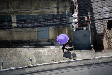 Salvador, Bahia, Brezilya - 28 Ocak 2022: Bahia 'nın başkenti Salvador' da elinde şemsiyeyle yürüyen bir yaya görülüyor..